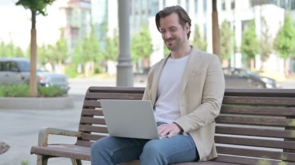 Homme Parlant Sur Appel Vidéo Tout Étant Assis Sur Banc — Video