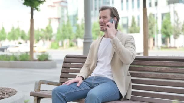 Angry Man Talking Phone While Sitting Bench — Stockvideo