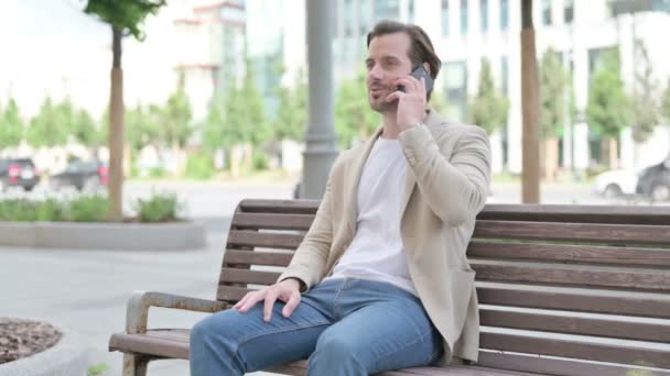 Man Talking Phone While Sitting Bench — Stockvideo