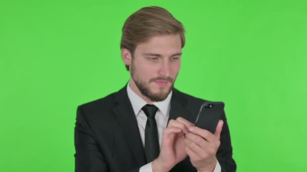 Young Adult Businessman Browsing Smartphone Green Background — Stock video