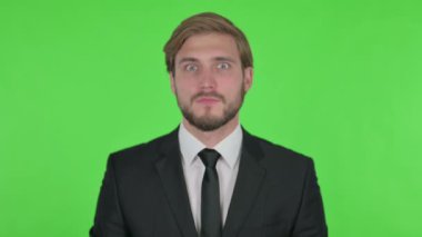 Surprised Young Adult Businessman Feeling Amazed on Green Background 