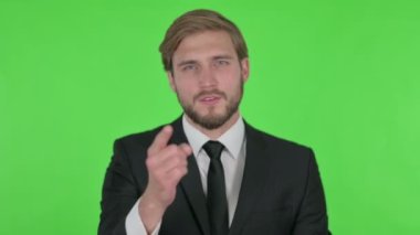 Angry Young Adult Businessman Arguing on Green Background 