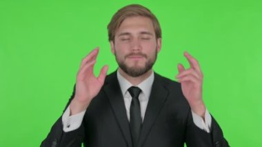 Young Adult Businessman with Headache on Green Background 