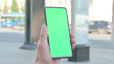 Close Up of Senior Old Man Using Smartphone with Green Screen Outdoor