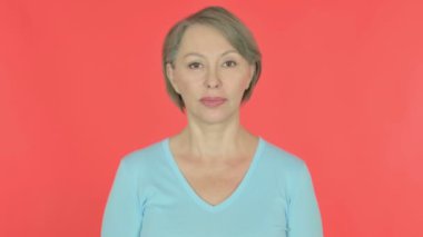 Thumbs Down by Senior Old Woman on Red Background 