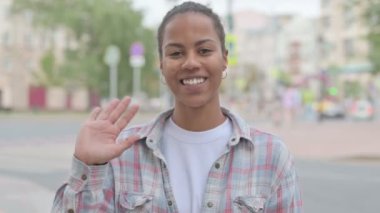Welcoming Young African Woman Waving Hand for Hello Outdoor