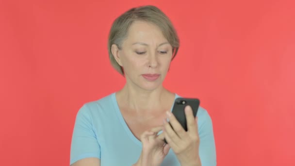 Senior Old Woman Browsing Smartphone Red Background — Video