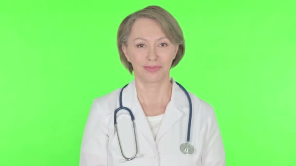 Senior Female Doctor Shaking Head Approval Green Background — Stok Video