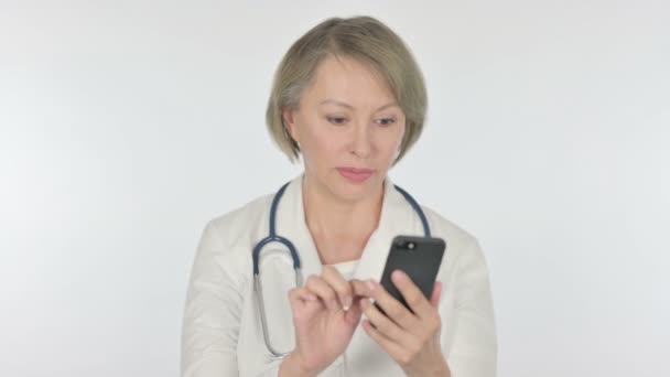 Senior Female Doctor Browsing Smartphone White Background — Vídeos de Stock