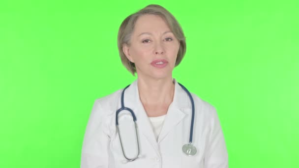Denying Senior Female Doctor Shaking Head Stop Green Background — Vídeo de stock