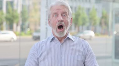 Portrait of Excited Senior Old Man Celebrating Success Outdoor 