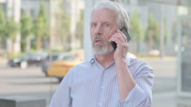 Portrait of Senior Old Man Talking on Phone Outdoor