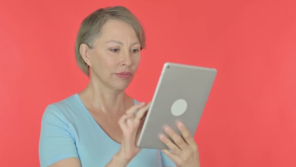 Ηλικιωμένη Γυναίκα Που Χρησιμοποιεί Ψηφιακή Ταμπλέτα Κόκκινο Φόντο — Αρχείο Βίντεο
