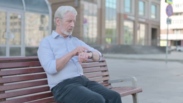 Senior Old Man Περιήγηση Στο Internet Για Smartphone Ενώ Κάθεται — Αρχείο Βίντεο