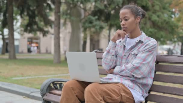 Thinking Young African Woman Using Laptop While Sitting Outdoor Bench — Stockvideo