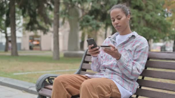 Young African Woman Upset Online Shopping Failure While Sitting Outdoor — Video
