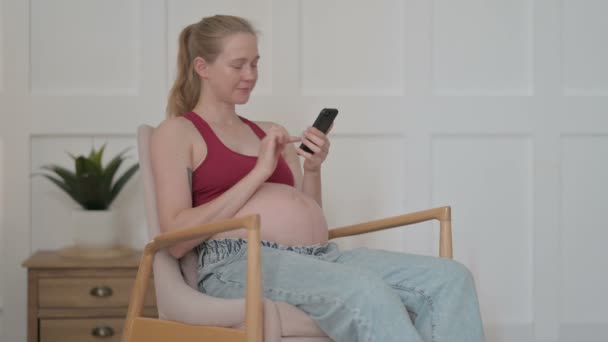 Έγκυος Νεαρή Γυναίκα Χρησιμοποιώντας Smartphone Περιήγηση Στο Internet — Αρχείο Βίντεο