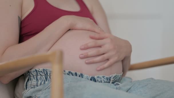 Close Pregnant Young Woman Stokes Her Big Belly While Sitting — Stockvideo