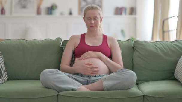 Сидящая Беременная Молодая Женщина Смотрит Камеру Гладя Живот — стоковое видео