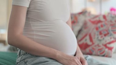 Close Up of Pregnant Young Woman Holding Her Big Belly after Removing Shirt