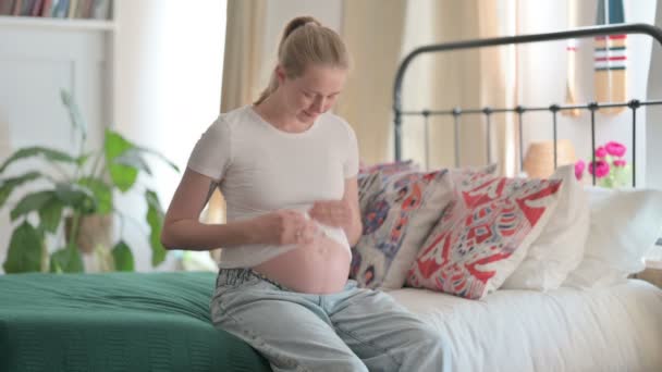 Ευτυχισμένη Έγκυος Νεαρή Γυναίκα Κρύβει Μεγάλη Κοιλιά Της Ενώ Κάθεται — Αρχείο Βίντεο