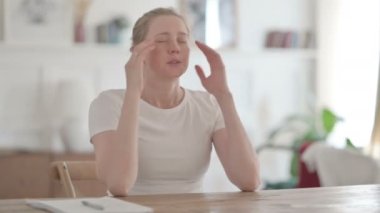 Young Woman having Headache while Sitting in Office