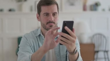 Casual Man Celebrating Success on Smartphone