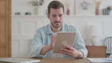 Casual Man using Tablet while Sitting in Office