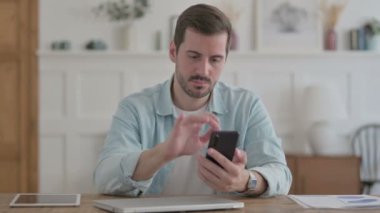 Casual Man using Smartphone in Office 