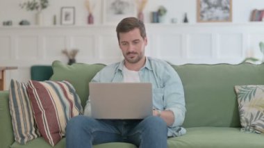 Casual Man with Laptop Feeling Angry on Sofa 
