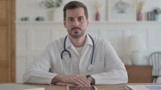 Male Doctor Smiling Camera While Sitting Clinic — Wideo stockowe