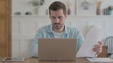 Casual Man Upset while Reading Documents at Wok