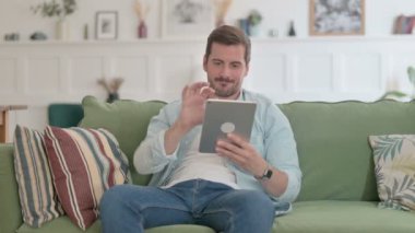 Casual Man Celebrating Success on Tablet on Sofa 