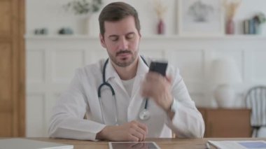 Male Doctor Talking on Phone in Clinic