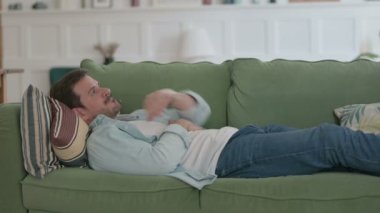 Casual Man having Headache while Sleeping in Bed