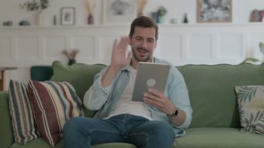Casual Man Talking on Video Call on Tablet on Sofa 