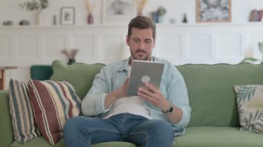 Casual Man using Tablet on Sofa 