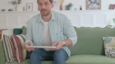 Casual Man Siting on Sofa, Opening Laptop