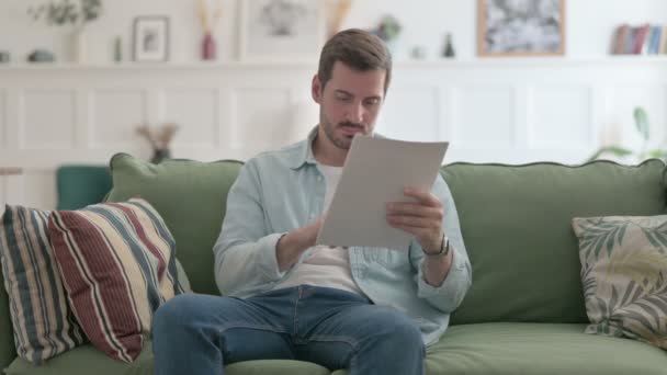 Casual Man Czytanie Dokumentów Kanapie — Wideo stockowe