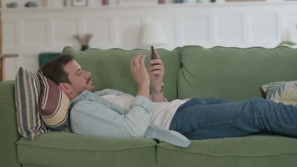 Casual Man Using Smartphone While Sleeping Bed — Vídeo de Stock