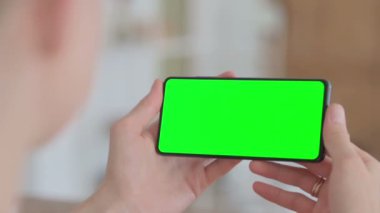 Close Up of Female Hand Holding Smartphone with Green Chroma Key Screen 