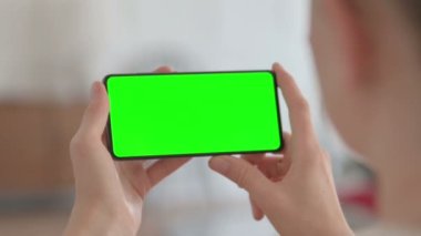 Close Up of Female Hand Holding Smartphone with Green Screen 