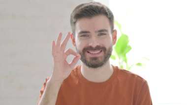Positive Creative Young Man showing OK Sign