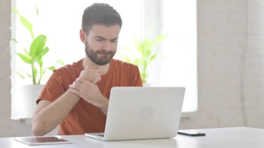 Creative Young Man having Wrist Pain while using Laptop in Office