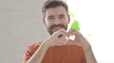 Creative Young Man showing Heart Shape by Hands