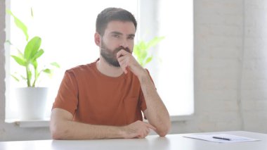 Creative Young Man Sitting in Office and Thinking