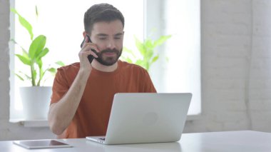 İş yerinde yaratıcı genç adam konuşuyor.