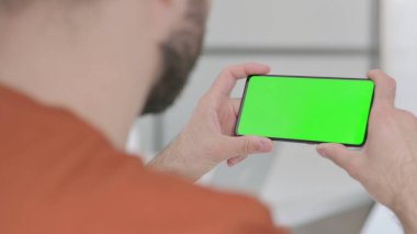 Creative Young Man Watching Smartphone with Chroma Screen