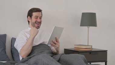 Yatakta Tablette Başarı Kutlaması Yapan Sakallı Genç Adam