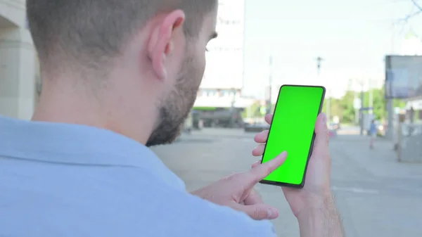 Man Using Smartphone with Green Screen Outdoor